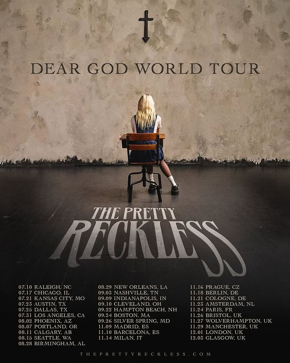 Person sits alone at desk facing a wall with a cross and "Dear God World Tour" text. Tour dates and "The Pretty Reckless" text below.